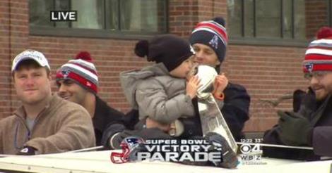 Tom Brady's son kissing the Super Bowl trophy during the parade